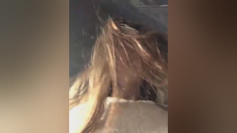 Media: Video of a woman with long, blonde hair, possibly in distress, her head tilted back, eyes closed, and mouth slightly open. Background is blurred and dimly lit.