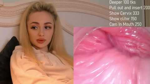 Media: A video of a blonde woman in a beige top, looking directly at the camera, with a close-up of her pink, moist inner mouth to the right. Text overlays indicate she's a cam girl.