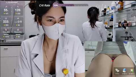 Media: Video of a female Asian scientist in a lab, wearing a white lab coat and face mask, with a male lab assistant behind her, both working with microscopes.