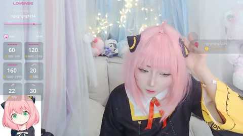 Media: A video of a young woman with pink hair, wearing a black and yellow anime-inspired outfit, being combed by a hand, in a softly lit, cozy room with white curtains and a plush bear.