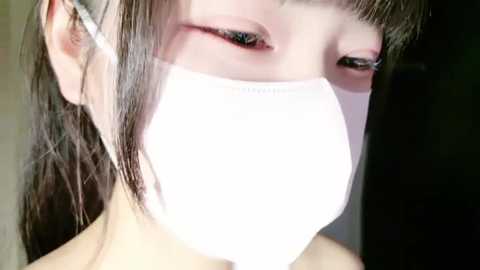 Media: Video of an Asian woman with light skin, straight dark hair, wearing a white medical mask, and bold red eyeshadow.