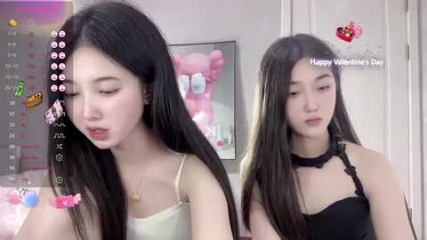 Media: A video of two young East Asian women with long black hair, one in a white camisole and the other in a black lace top, in a romantic bedroom setting.