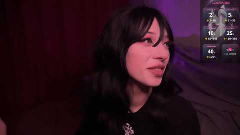 Media: Video of a young woman with long black hair, wearing a black top, in a dimly lit room with purple and red lighting. Live stream overlay displays her chat, showing 40 viewers and 2.5K coins earned.