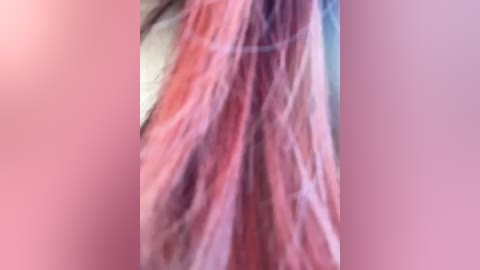 Media: A close-up video of a person's long, wavy, pink hair, with a blurred background. The hair appears soft and voluminous, cascading down. The image is somewhat grainy, possibly due to low light or a digital filter.