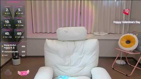 Media: A video of a white leather recliner chair in a room with pink heart decorations and a Valentine's Day message.