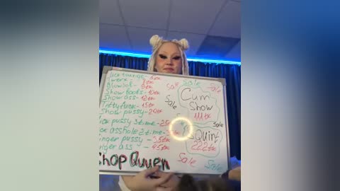 Media: Video of a blonde woman in a bunny costume holding a whiteboard with various sexual acts and locations, set against a dimly lit room with blue lighting and a \"Shop Riven\" logo.