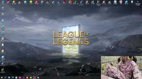 Media: Video of a computer screen displaying a dark, stormy mountain landscape with a glowing \"League of Legends\" logo. Below, an image of a person in floral pajamas reading a newspaper.