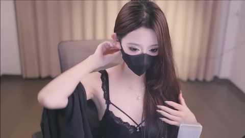 Media: Video of an Asian woman with long, straight black hair, wearing a black lace bra and face mask, adjusting her glasses in a modern, beige-tiled room.