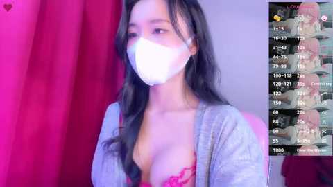 Media: Video of an Asian woman with long black hair, wearing a white mask and pink lace bra, standing against a red curtain. Screen overlay with live streaming stats.