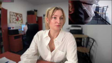 Media: Video of a blonde woman in a white shirt, seated in a modern office. Inset image shows a close-up of a man's face with a large mole on his cheek.