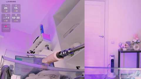 Media: Video of a laboratory setup with a white, sleek machine, a clear glass container, and a person's hand holding a syringe. The room is brightly lit, with purple and pink accents.