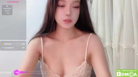 Media: A video of an Asian woman with long black hair, wearing a light pink lace bra, captured in a bathroom with a white curtain.