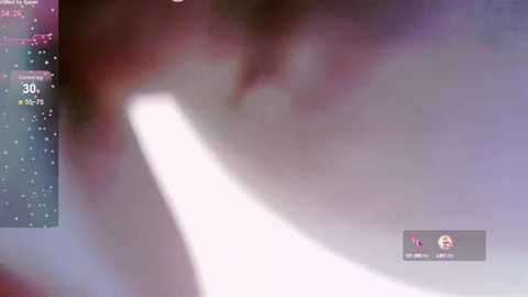 Media: Video of a blurred, abstract image with a bright, white, light source on the left, surrounded by a gradient of pink and purple hues. A small, fuzzy figure and a digital interface with numbers are partially visible in the bottom right corner.