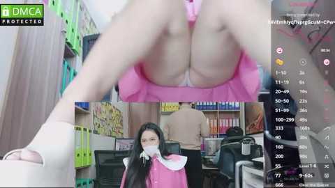 Media: Video of a woman in a pink dress bending over, revealing her buttocks. Background shows a library with shelves and a man in a beige shirt.