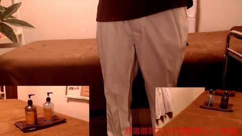 Media: A video of a person in white pants standing in front of a massage table, with a tray of massage oils on the floor.