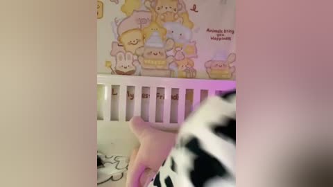 Media: Video of a baby's crib with a cow-patterned bumper, adorned with stuffed animals and a \"Welcome Baby\" sign.