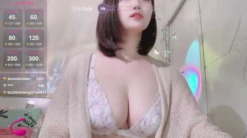 Media: A video of a fair-skinned, short-haired Asian woman in a floral bra, beige cardigan, and makeup. Background shows a bright, futuristic room with neon lights and a green plant.