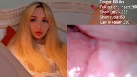 Media: A video of a blonde woman with long hair, wearing a white shirt, reclining on a bed. Close-up of a pink, moist, and detailed vulva.