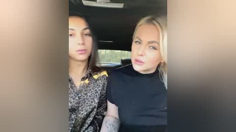 Media: Video of two women in a car, one with long dark hair, the other with blonde hair. They are dressed in leopard print and black, respectively. Background shows the car's interior.