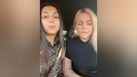 Media: Video of two women with medium skin tones, one with long dark hair in a leopard print blouse, the other with blonde hair in a black top.