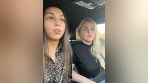 Media: Video of two women in a car, one with long, straight hair, wearing a leopard-print blouse, and the other with long, wavy blonde hair, dressed in a black top.