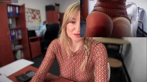 Media: Video of a blonde woman with fair skin, wearing a patterned long-sleeve top, sitting at a desk in an office. Close-up inset shows a close-up of her buttocks.