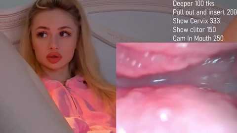 Video of a blonde woman with fair skin, wearing pink lipstick, lying on a white bed. Close-up of her mouth and tongue, showing oral sex.