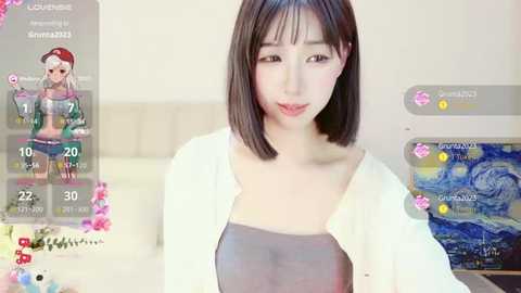 Media: A video of a young Asian woman with straight, shoulder-length black hair, wearing a white cardigan over a gray top, indoors with a beige couch and a Monet painting in the background.