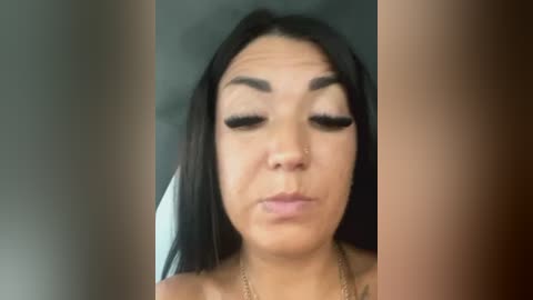 Media: Video of a woman with long black hair, light brown skin, wearing black eyeliner and mascara, making a pouty face.