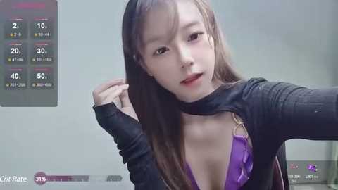 Media: A video of an Asian woman with fair skin, long brown hair, wearing a black choker, purple bra, and a black top. She has a neutral expression. The background shows a live stream display with temperature and weather data.