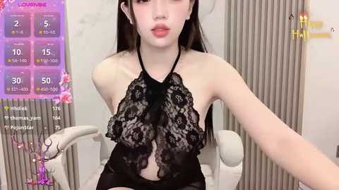 Media: Video of a slender Asian woman with long black hair, wearing a black lace halter top, seated indoors, with a virtual fitness app interface overlaying the background.