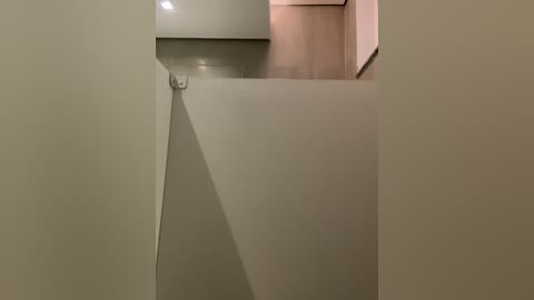 Media: Video of a minimalist, beige bathroom interior featuring a sleek, rectangular bathtub with a chrome faucet, a modern sink, and a muted beige wall.