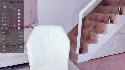 Media: A video of a modern, minimalist living room featuring a white leather chair, a white staircase, and a soft pink carpet. The background includes a pink wall and a white bed with a plush, pink throw pillow.