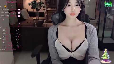 Media: Video of an Asian woman with black hair, wearing a revealing black and white top, sitting on a black office chair in a modern living room.