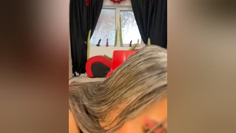 Media: A video shows a person with gray hair and a colorful, abstract painting on a window, framed by black curtains. The room has a modern, artsy vibe.