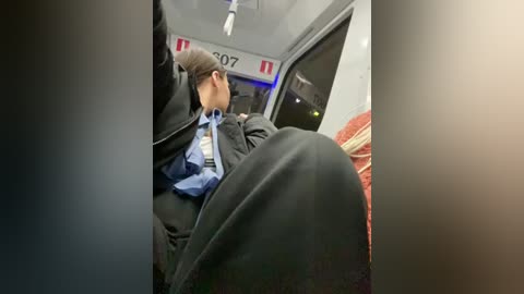 Media: A video of a man in a black suit and tie sleeping on a bus seat, with a blurred view of a bus window and a patterned blanket.