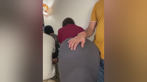 Media: Video of a man in a mustard shirt, grabbing a woman's buttocks in a public place; others in the background, blurred.