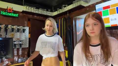 Media: Video of two young women in a bar, one blonde wearing a crop top and jeans, the other redhead in a white T-shirt.