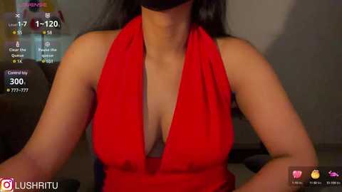 Media: Video of a woman in a red halterneck dress, wearing a black mask, with a blurred background. Streaming platform logo visible.