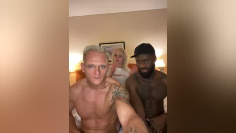 Media: Video of three shirtless men in a dimly lit room, with a blonde woman in the background wearing a white shirt.