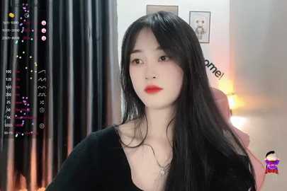 Media: Video of an East Asian woman with long black hair, red lipstick, and a black top, in a dimly lit room with a \"cam model\" watermark.