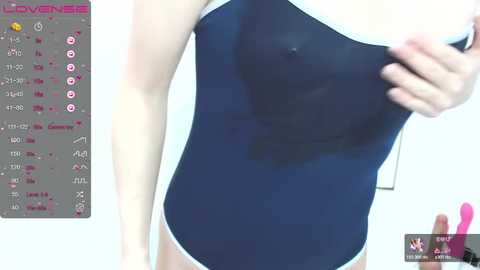 Media: A video of a woman in a blue swimsuit, partially covering her breasts, with a digital interface displaying game statistics in the background.