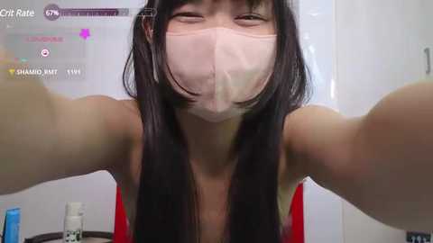 Media: Video of an East Asian woman with long black hair, wearing a pink face mask, red tank top, and a blue drink in a bathroom, with a \"Chat Rate\" app open in the background.