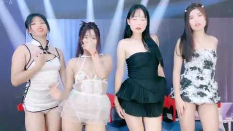 Media: Video of four Asian women in various revealing, strapless dresses on a stage with white and blue lights, set against a blurred, modern indoor background.