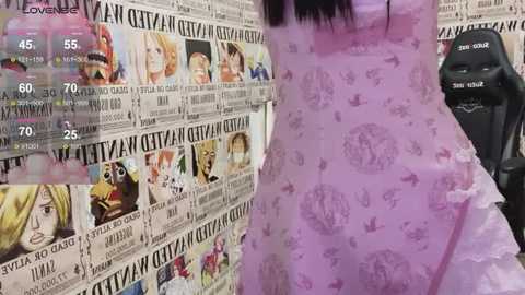 Media: A video of a person wearing a purple dress with a newsprint pattern, standing beside a black gaming chair with a \"Razer\" logo. The background is covered in newsprint images of various anime characters.