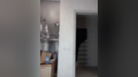 Media: A blurred video of a modern, minimalist kitchen with white cabinets, a black stove, and a wooden countertop. The image is slightly out of focus, making details difficult to discern.