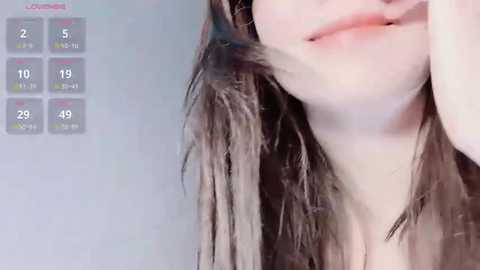 Media: A close-up video of a young woman with long, wet brown hair, partially covering her face, set against a gray background. A weather app in the top left corner shows temperatures and humidity levels.