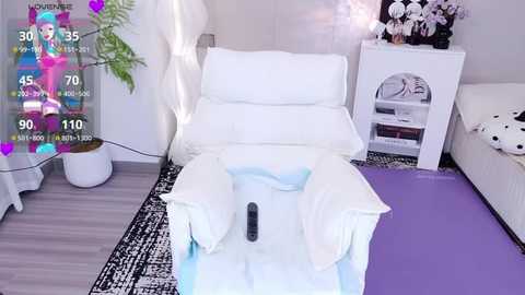 Media: Video of a woman lounging on a white couch in a modern, minimalist living room with a purple mat and white wall art.