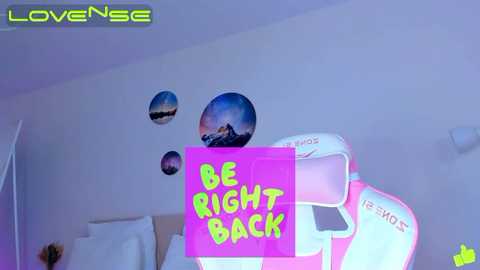 Media: Video of a white wall with a circular sticker of a sunset, a neon pink sign saying \"BE RIGHT BACK,\" and a white gaming chair labeled \"MOUSE.\