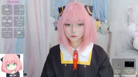 Media: Video of a young Asian woman in a cosplay outfit, featuring pink hair, green eyes, and a black and yellow sailor dress with a red tie. Background shows a white wall with hanging clothes.